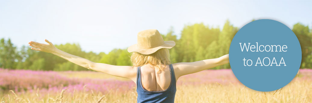 Woman in a field of flowers with her arms out wide