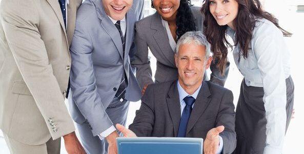 16236267 - young business people standing behind their director proudly showing the laptop